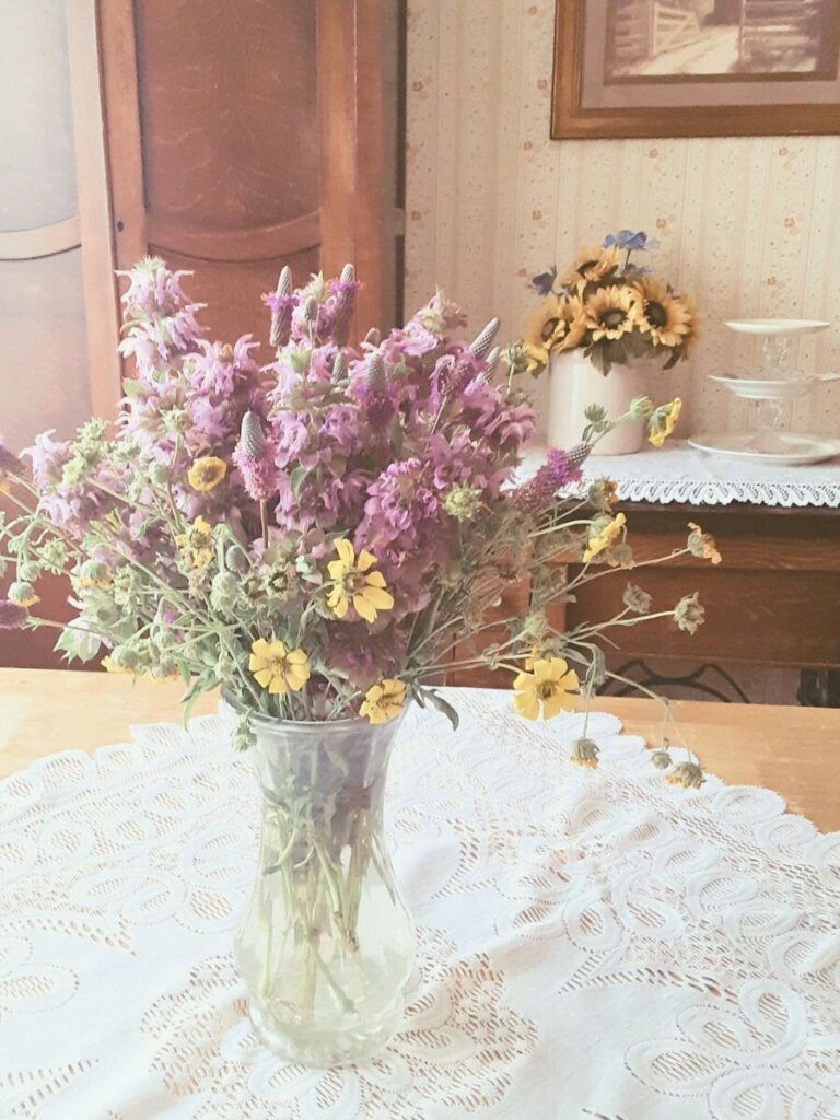 vase of wildflowers sitting on a dining room table