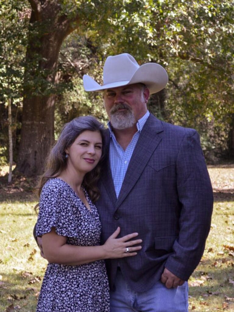 man and woman standing in a woodland yard