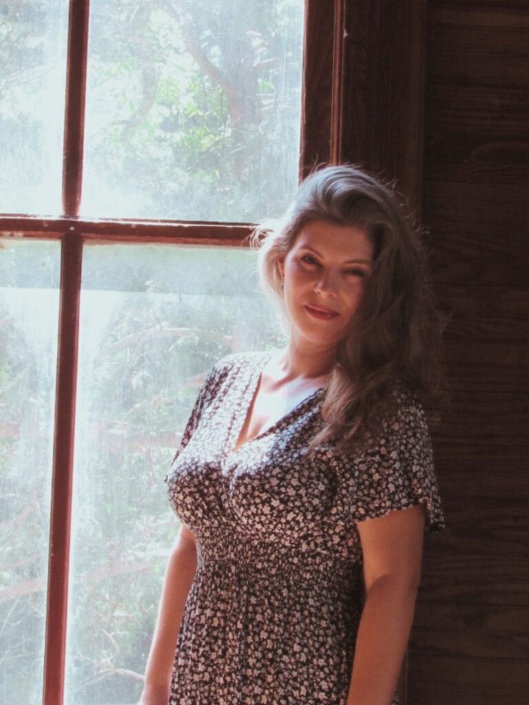 woman standing in front of a window in an old house